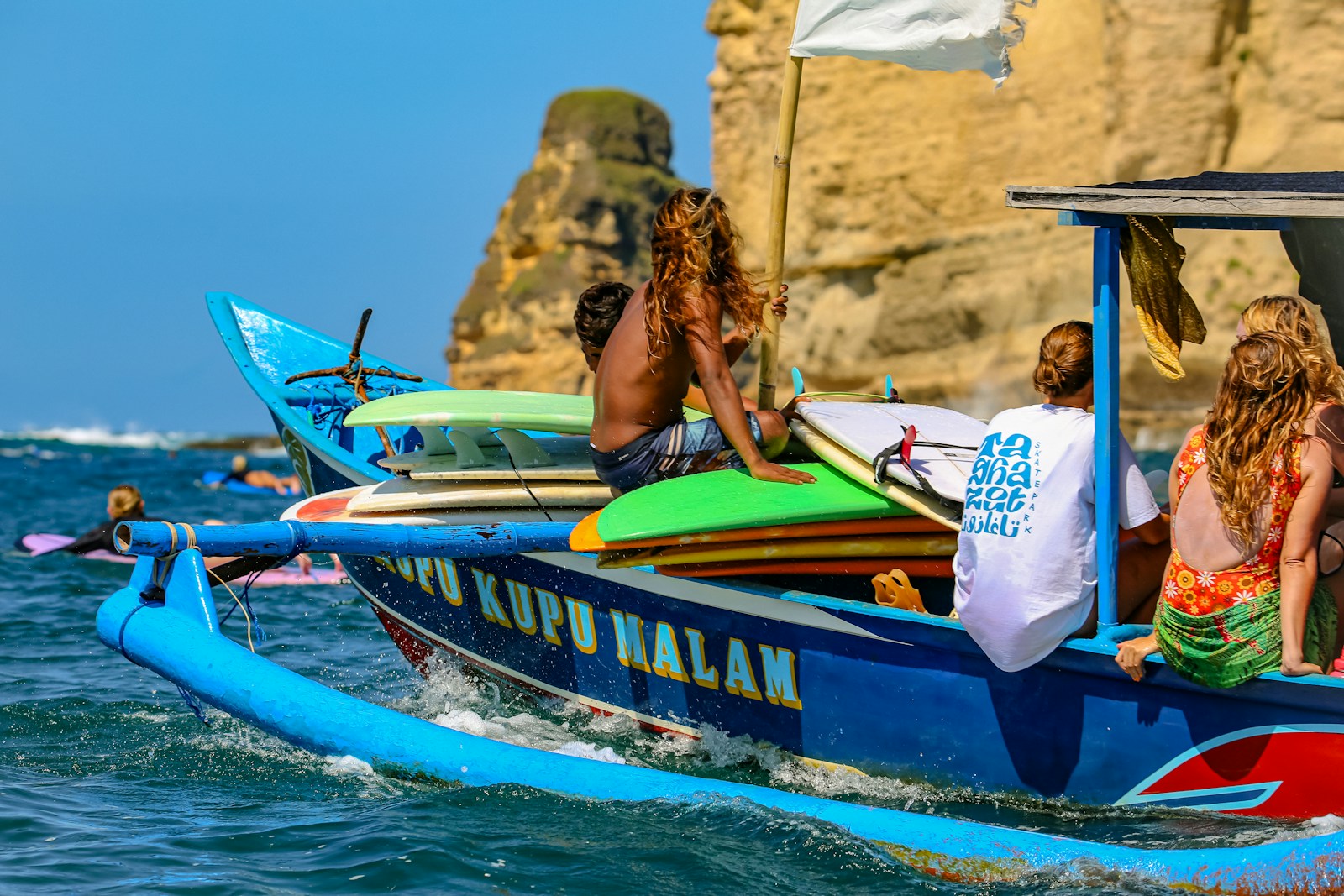 A group of people riding on the back of a blue boat