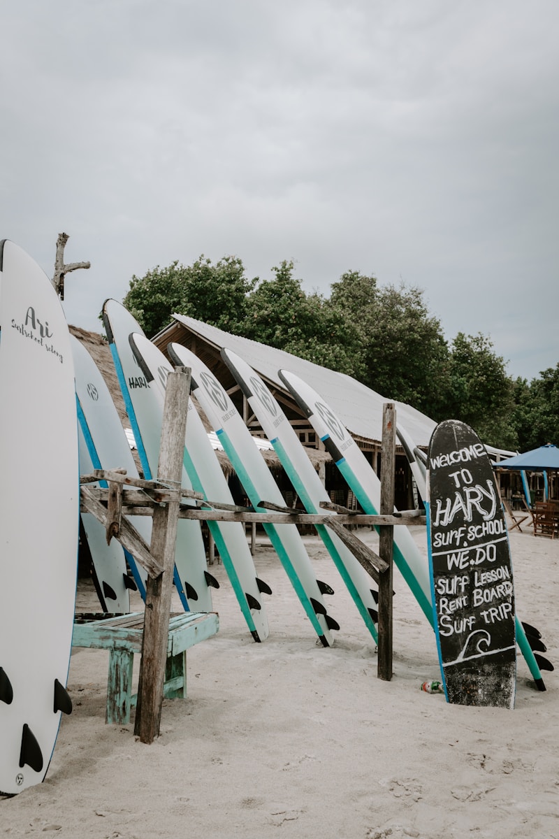 a bunch of surfboards that are leaning against a fence